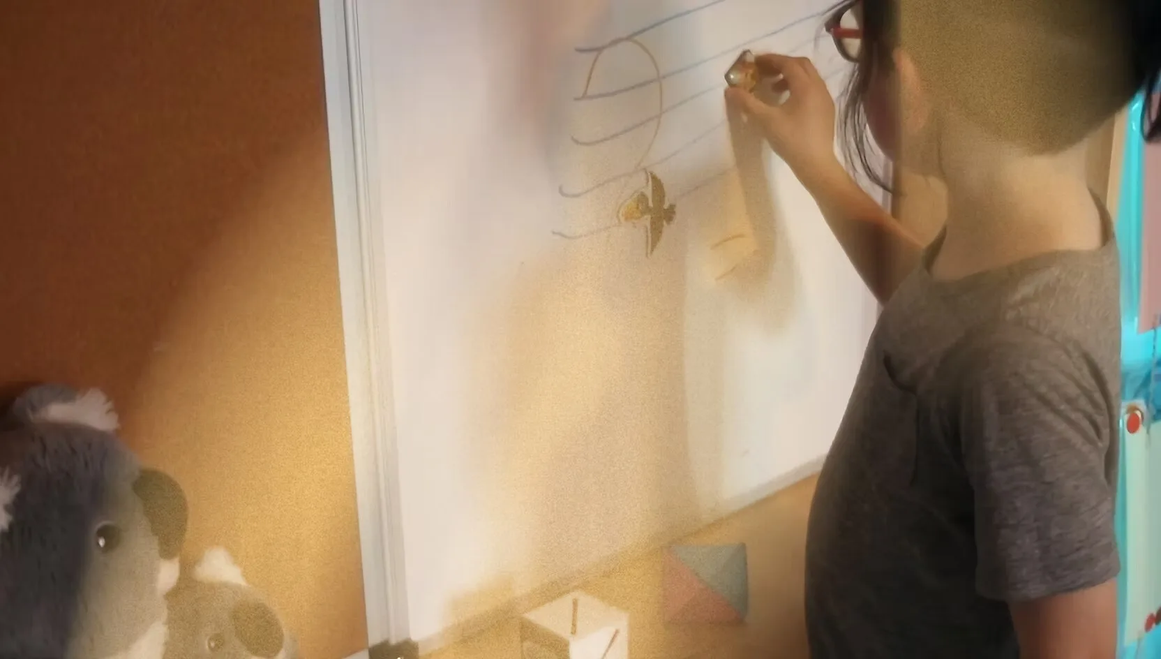A student writes out a melody on the whiteboard during a group class.