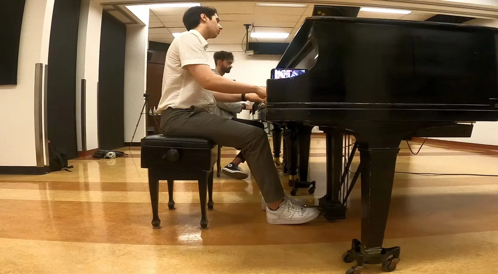Mircea at the grand piano alongside a fellow musician.