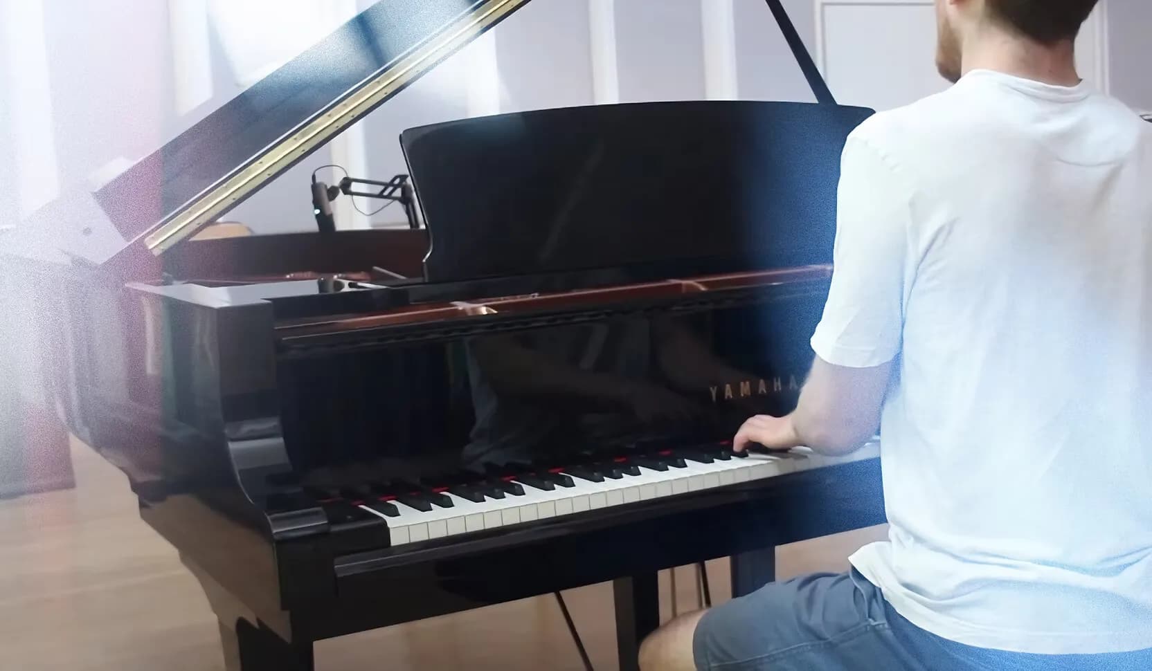 Mircea from behind, at the Yamaha grand piano, mid-performance.